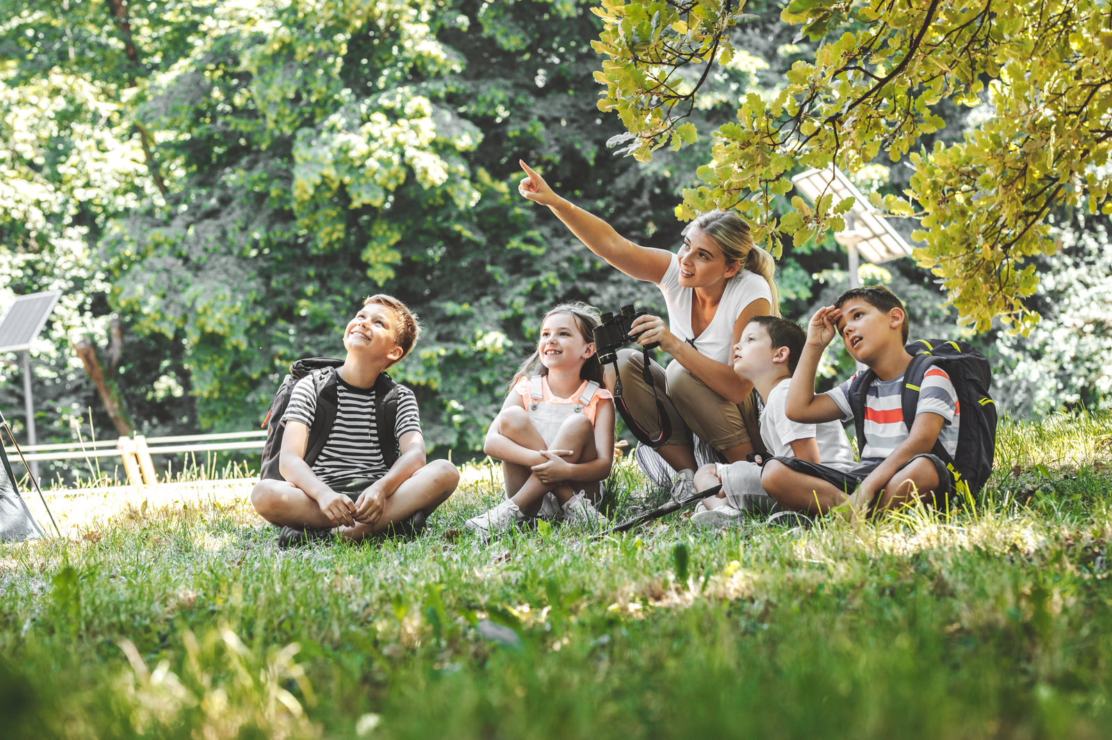 Family relaxing on the grass under trees in a Kemptville park