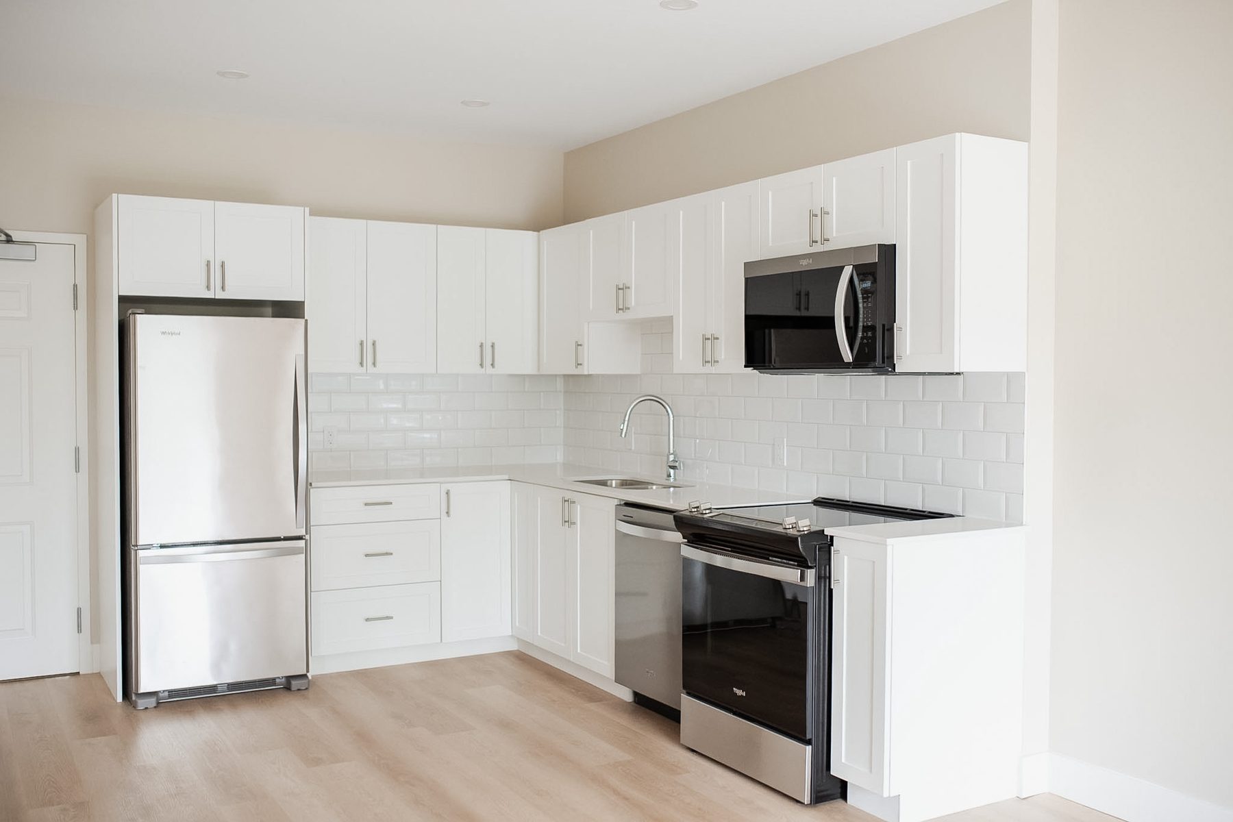 Kitchen in a Parkside Living suite — white cabinetry, subway tile and stainless steel appliances